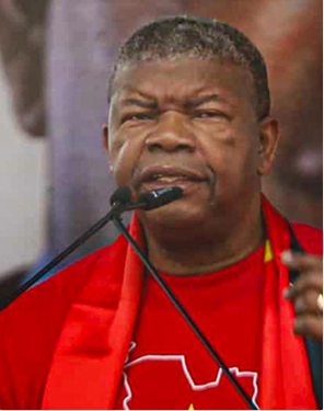 João Lourenço discursa em acto político do MPLA, usando vestuário vermelho do partido, durante um evento relacionado à sua recandidatura à liderança partidária em Angola.